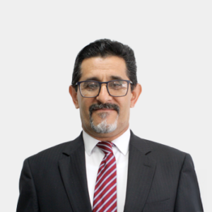 The professor of the School of Petroleum Engineering, Emiliano Ariza León, is presented to the general public and the educational community. The photo was taken in close-up, with a white background, and the professor is situated in the center.