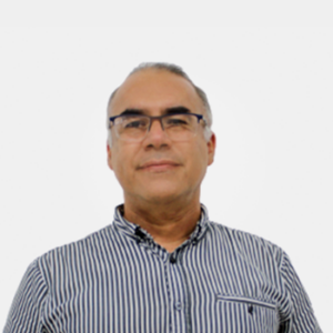 La foto fue tomada en primer plano, fondo blanco y el profesor Guillermo Mejia está situado en el centro.