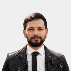 Se presenta al público general y la comunidad educativa al profesor de la Escuela de Estudios Industriales y Empresariales, Juan Felipe Reyes Rodríguez. La foto fue tomada en primer plano, fondo blanco y el profesor está situado en el centro.