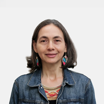 The professor of the School of Social Work, Raquel Méndez Villamizar, is presented to the general public and the educational community. The photo was taken in close-up, with a white background, and the professor is positioned in the center.